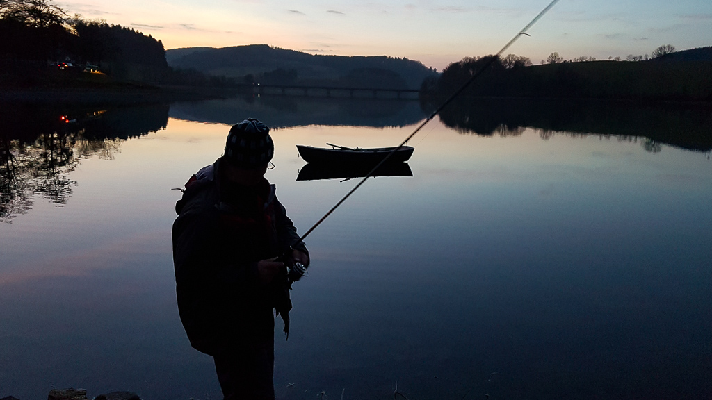 Herrenloses Boot das vom Angler ans Ufer gezogen wird