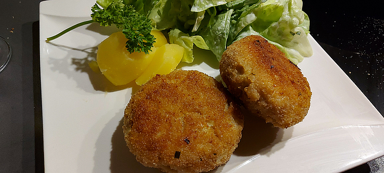 Angerichtete Hechtfrikadelle mit Beilage