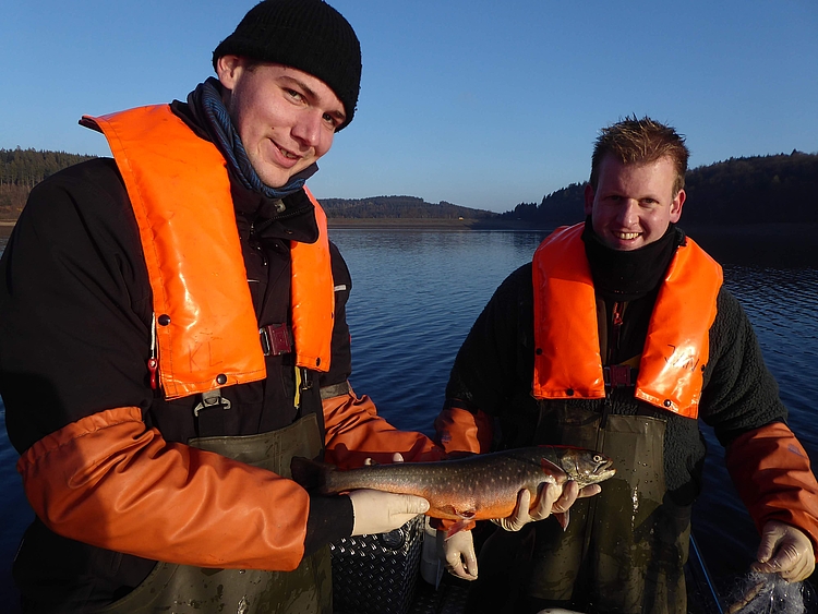 Angler mit gefangenen Seesaibling